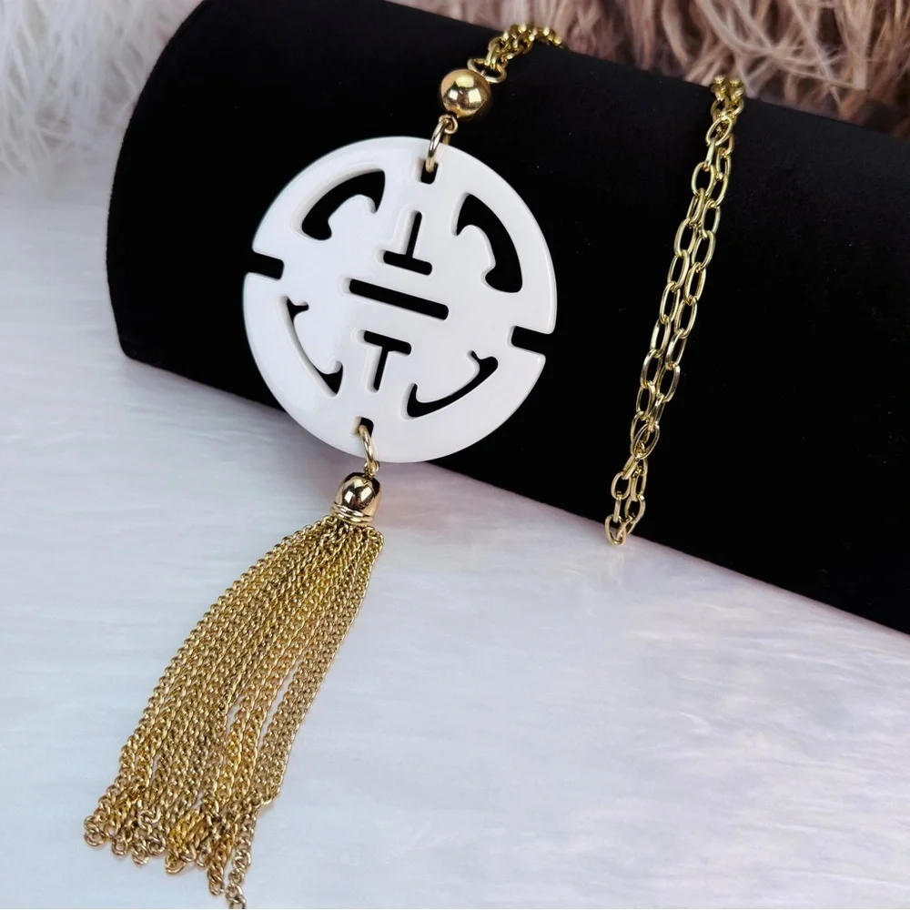 Long, goldtone, costume necklace, with large white pendant, and metal fringe